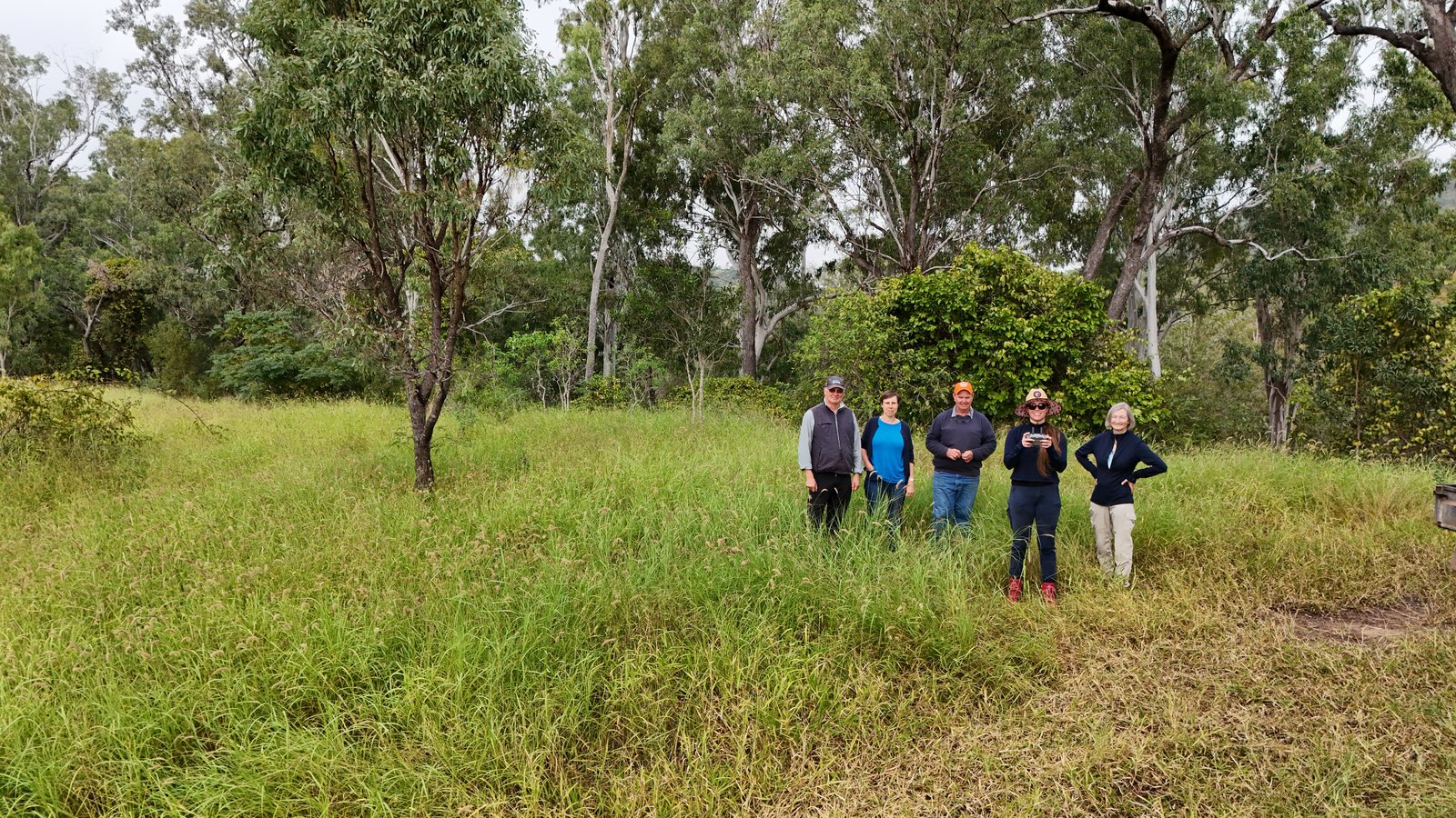 A group of people together among the trees and long grass at Moora Plains